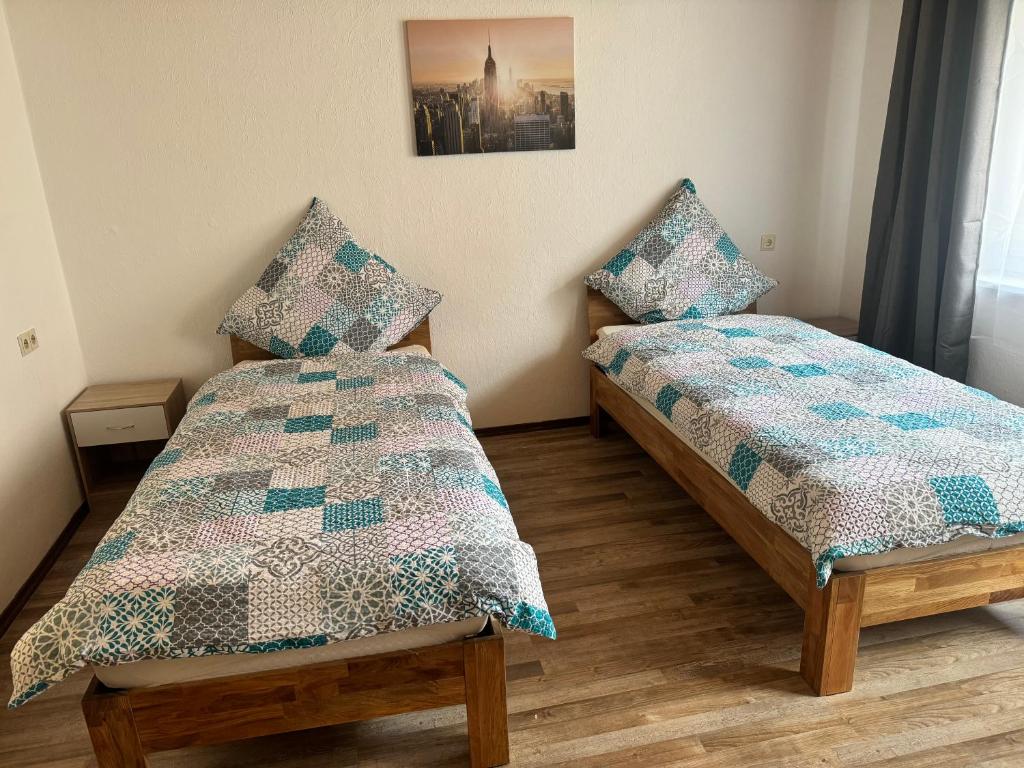 a bedroom with two beds and a picture on the wall at Monteurwohnung Naila in Naila