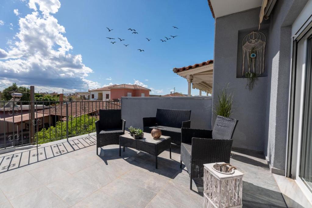 a patio with chairs and a table on a balcony at Elviras houses II in Agria