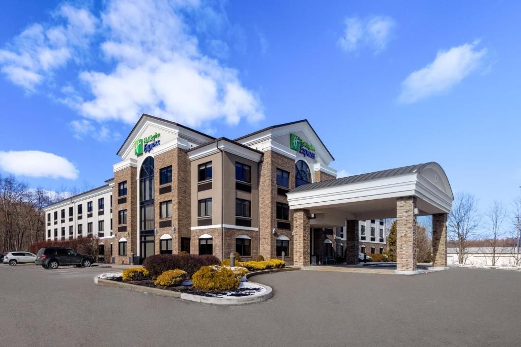 un hotel frente a un edificio con aparcamiento en Holiday Inn Express Grove City - Premium Outlet Mall, an IHG Hotel, en Grove City