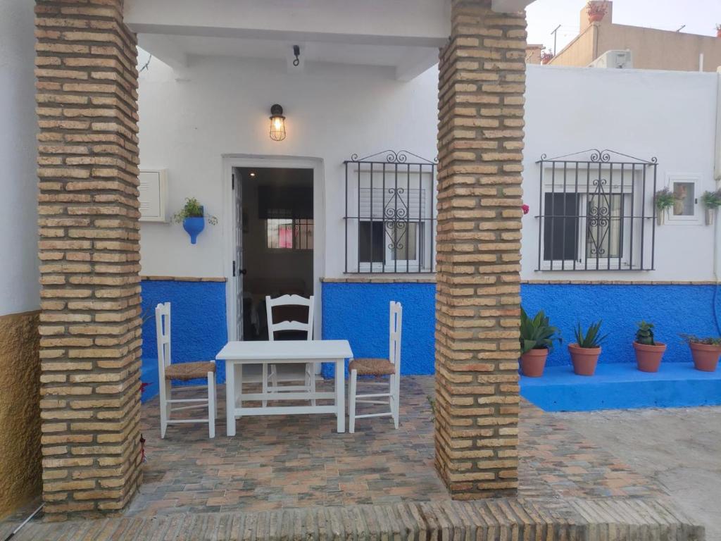 a table and chairs on a patio with blue walls at Casa de la abuela in Sanlúcar de Barrameda