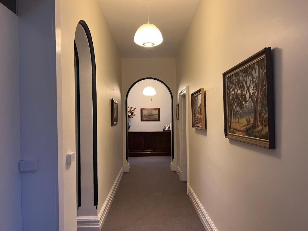 a hallway with an archway and paintings on the walls at Arthurton Central in Hobart