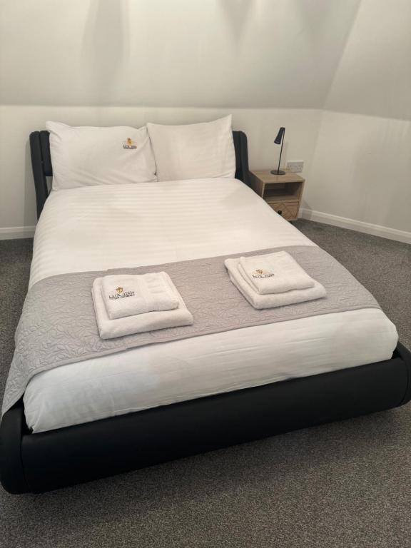 1 cama grande con 2 toallas encima en Apartology Manchester en Mánchester