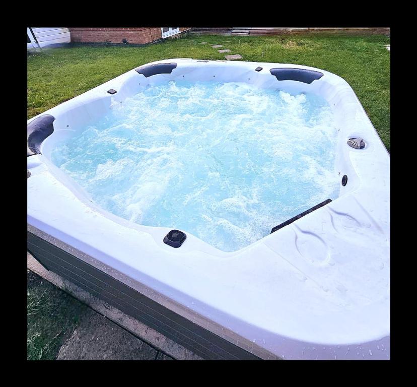 a bath tub filled with water in a yard at The Opulent House Kent in Sheerness