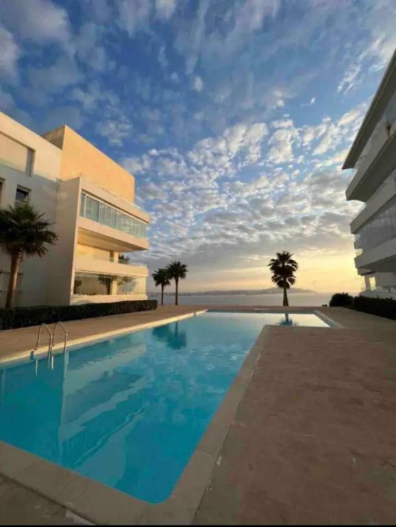 a swimming pool in front of a building at APPARTEMENT 5 étoiles VUE SUR MER in Tangier