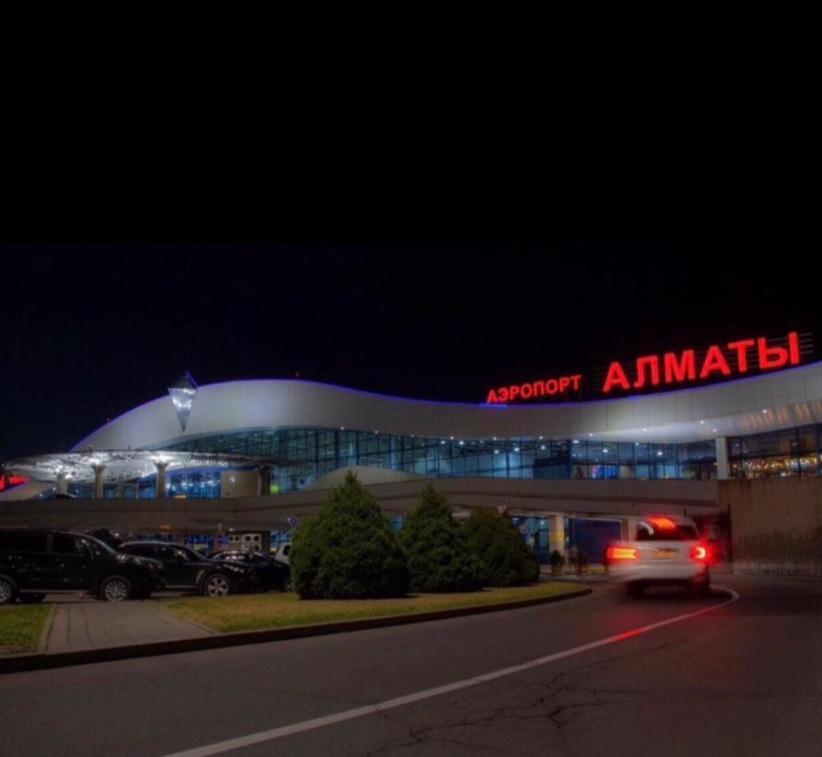 un'auto passa davanti a un aeroporto di notte di Апартаменты на Ахметова 10 a Turksib