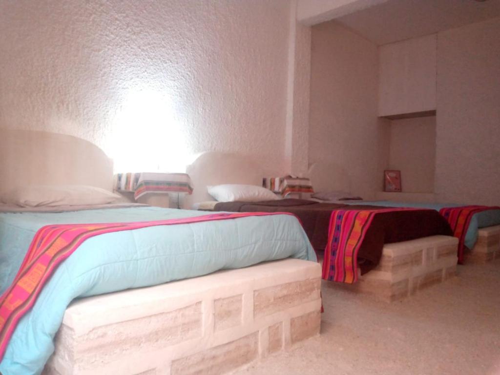 een slaapkamer met 2 bedden en een bank. bij salt beds of salt hostal in Uyuni