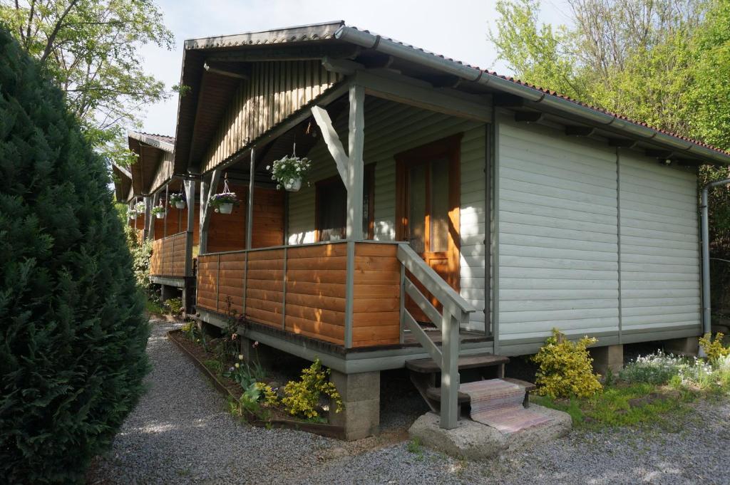 ein winziges Haus mit einer Veranda und einer Treppe dahin in der Unterkunft Natura Chalets in Praid