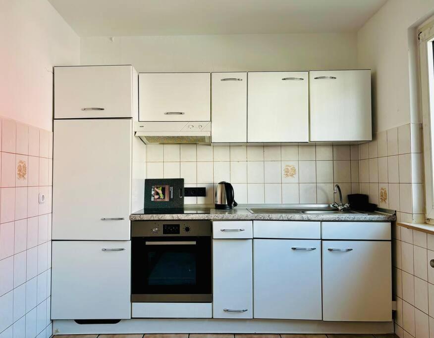 a kitchen with white appliances and white cabinets at Gemütliche Wohnung in Sankt Augustin in Sankt Augustin