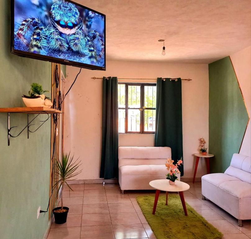 un soggiorno con TV e divano di Casa Aeropuerto Mérida, Yucatán a Mérida