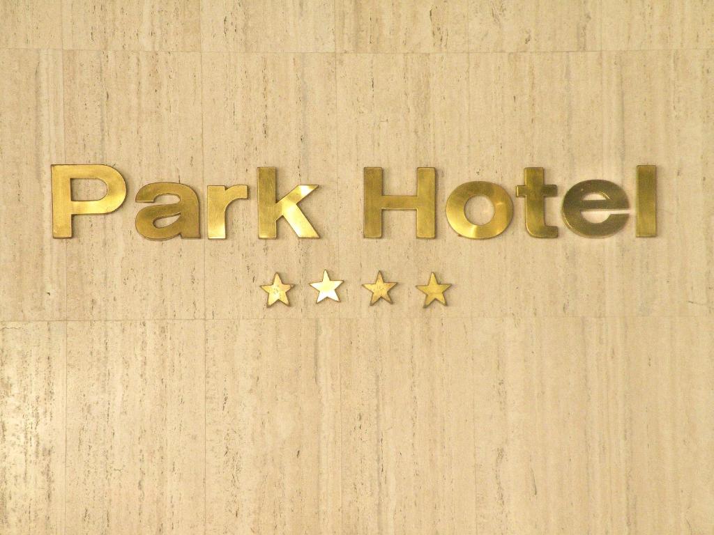 un cartello di un hotel nel parco su un muro con stelle di Park Hotel Mérida a Mérida