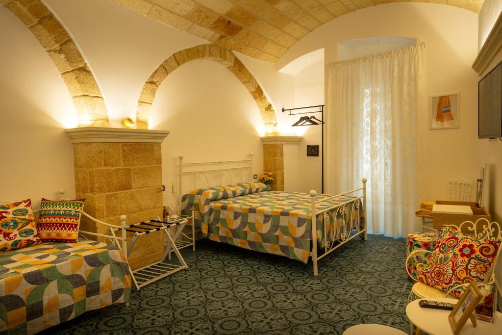 um quarto com 2 camas e um sofá em La Terrazza Nel Borgo B&B em Copertino