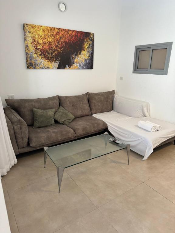 sala de estar con sofá y mesa de cristal en Sweet li en Ashkelon