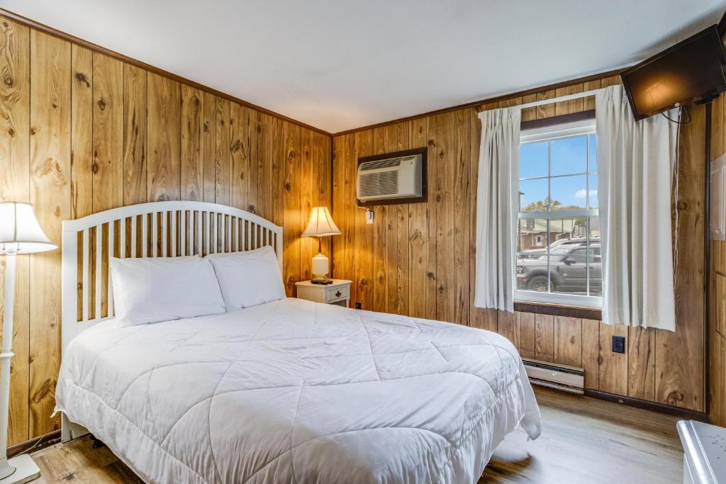 a bedroom with a bed and a window at The Inn at Lewes in Rehoboth Beach