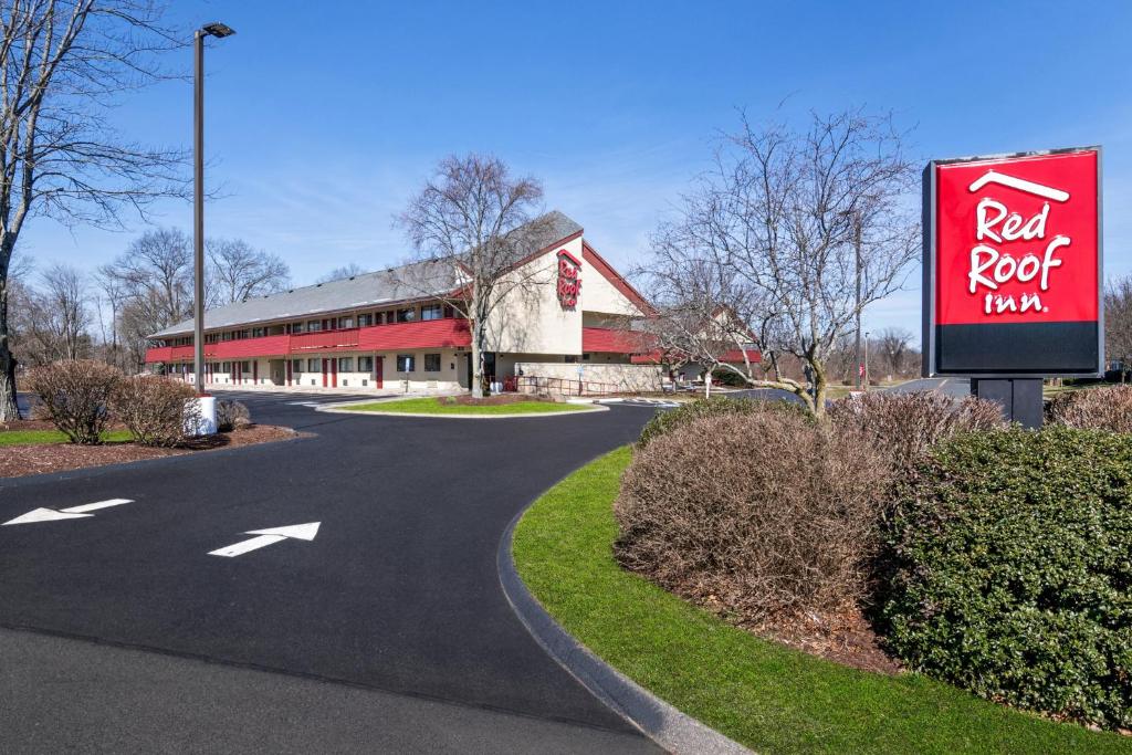 una señal roja de la posada frente a un edificio en Red Roof Inn Enfield, en Enfield