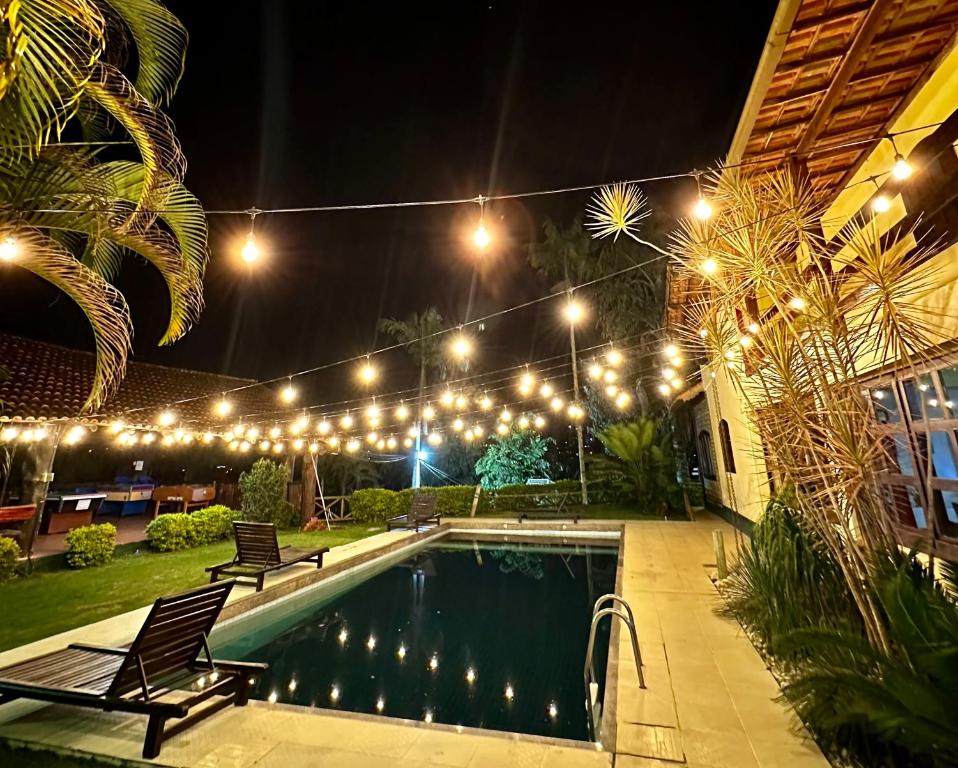 a swimming pool at night with lights above it at Pousada Melodia in Nova Friburgo