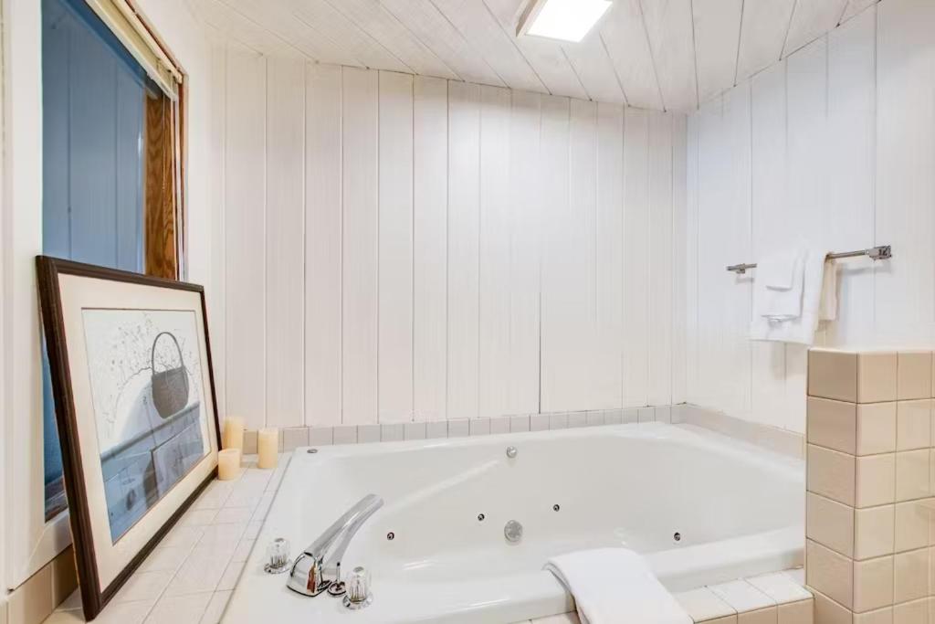 uma banheira branca numa casa de banho branca em Lighthouse Cove Condo Resort em Wisconsin Dells