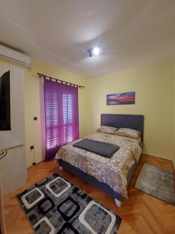 um quarto com uma cama e uma janela roxa em Barcelona Apartments em Tivat