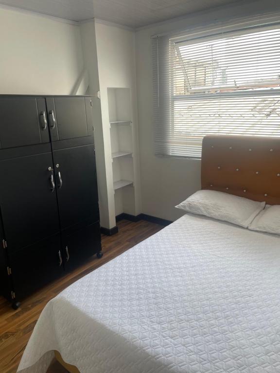 Un dormitorio con una cama y una ventana en The Lofts Urbanos Manizales, en Manizales