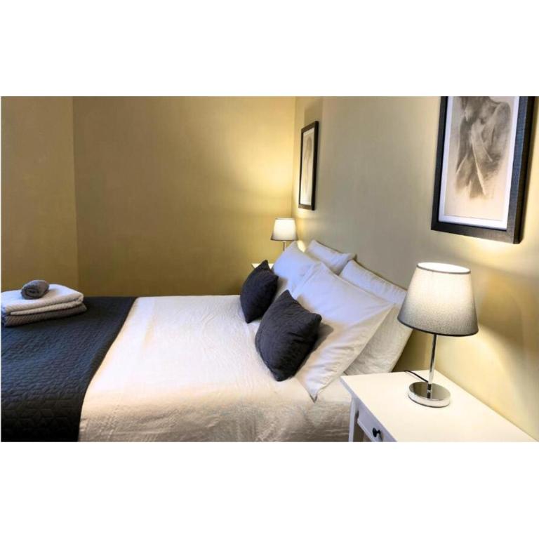 een slaapkamer met een groot bed met zwarte kussens bij Stunning stay 6 minutes from NEC and Birmingham Airport in Solihull