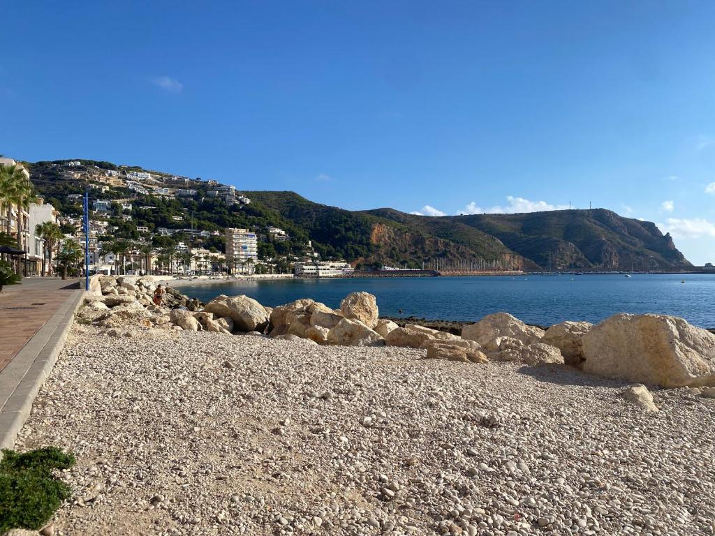 a beach with rocks and a body of water at Javea's Port apartment in Jávea