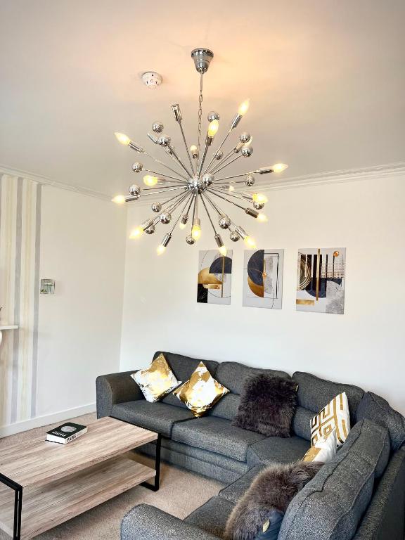 a living room with a couch and a chandelier at Private Parking, Urban Comfort & City Haven in Plymouth