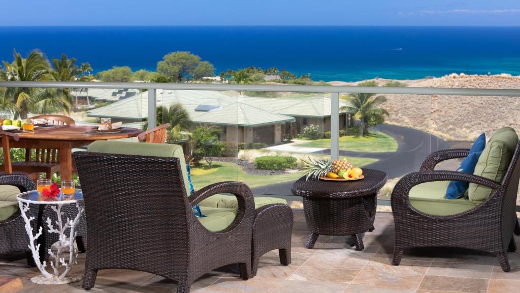 a patio with chairs and tables and the ocean at Beautiful Ocean Villa Beautiful Mauna Kea Home with Sunsets and Ocean Views in Hapuna Beach