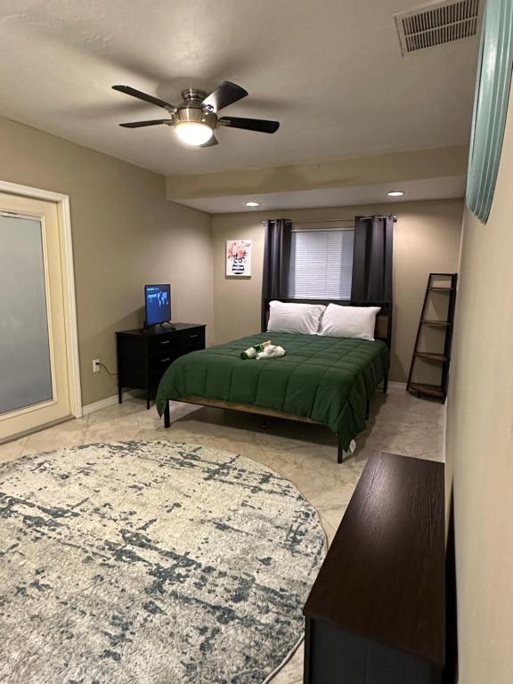 Schlafzimmer mit einem grünen Bett und einem Deckenventilator in der Unterkunft Private rooms in Spacious Siesta Key home - Huge Backyard in Sarasota