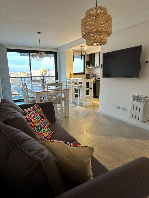 a living room with a couch and a kitchen with a view at Departamento Paso 3244 in Mar del Plata