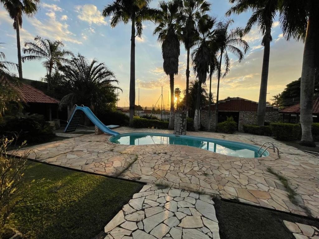 una piscina con un tobogán en un patio con palmeras en Hospedaria Monterrey en Monte Mor