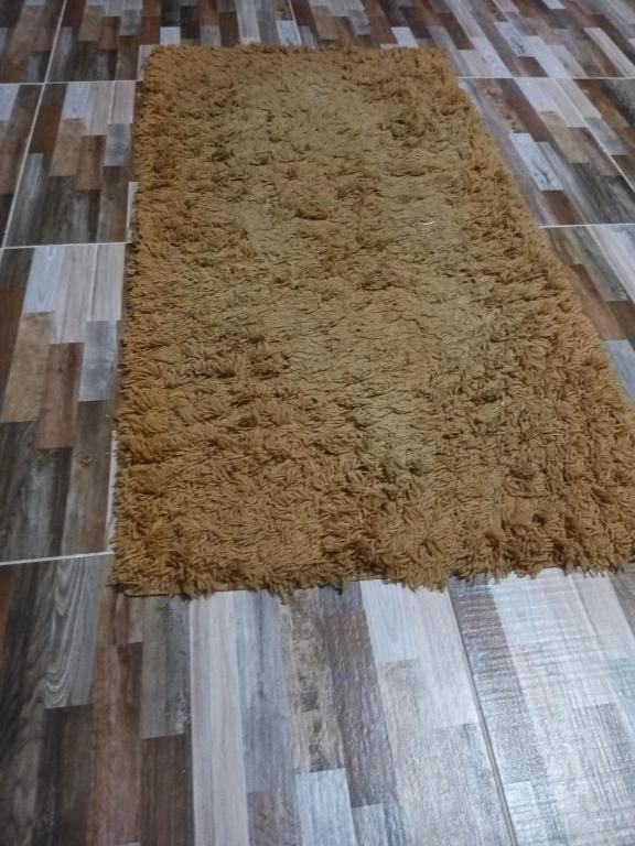 alfombra marrón sobre suelo de madera en Masr om adonia, en Kafr Şaqr