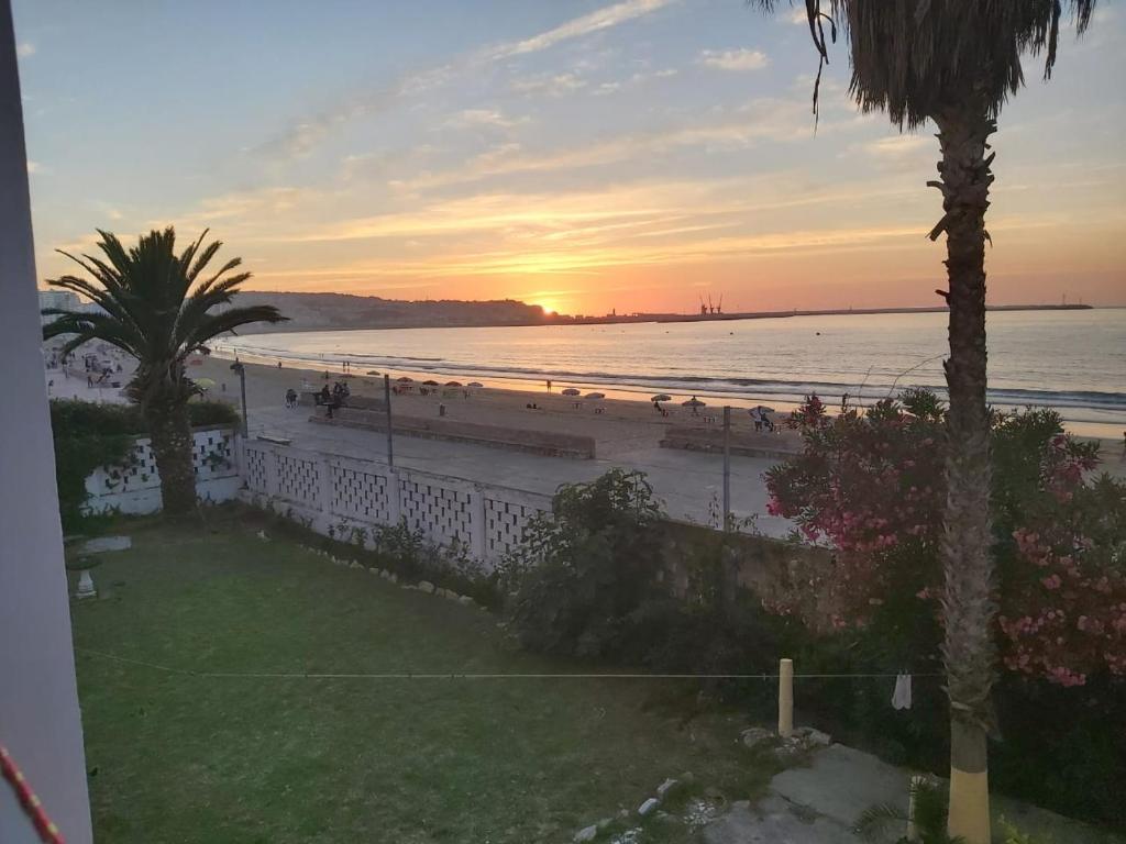 einen Blick auf den Strand bei Sonnenuntergang vom Balkon aus in der Unterkunft la belle vue tanger R in Tangier