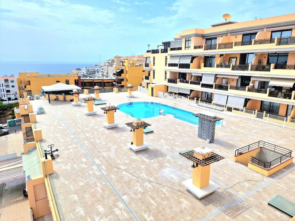 Cet appartement comprend une terrasse avec une piscine et des bâtiments. dans l'établissement Sunset Ocean Views Los Gigantes by HRTenerife Net, à Puerto de Santiago