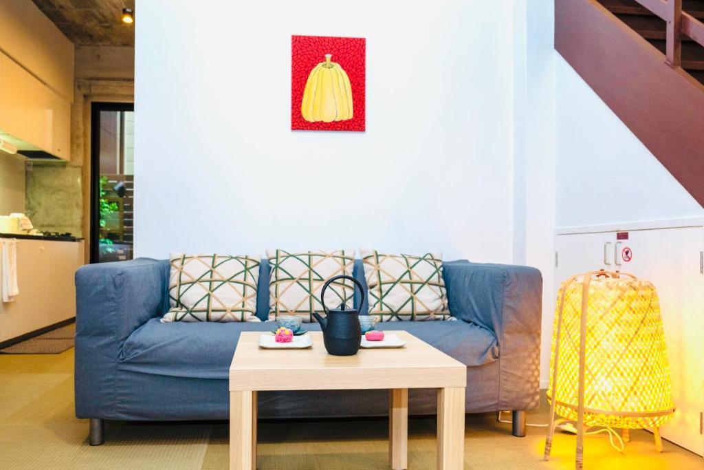 a living room with a blue couch and a table at Nishihan in Kyoto