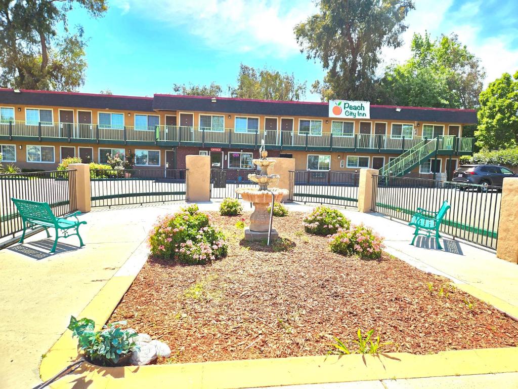 a building with two green benches in front of it at Peach City Inn - Marysville/Yuba City in Marysville