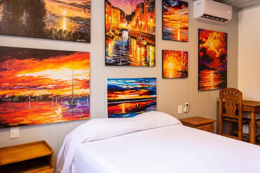een slaapkamer met schilderijen aan de muur bij Jungle house with a pool in Akumal