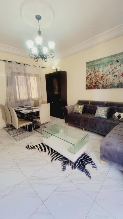 ein Wohnzimmer mit einem Sofa und einem Tisch in der Unterkunft APPARTEMENT 2chambres salon ouest foire en bordure de la route in Dakar