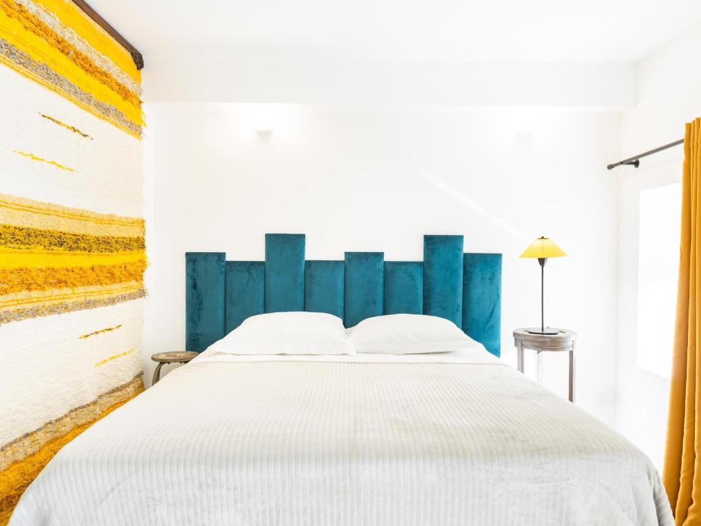 una camera con un grande letto con testiera blu di Gîte Mortagne-sur-Sèvre, 1 pièce, 2 personnes - FR-1-426-482 a Mortagne-sur-Sèvre