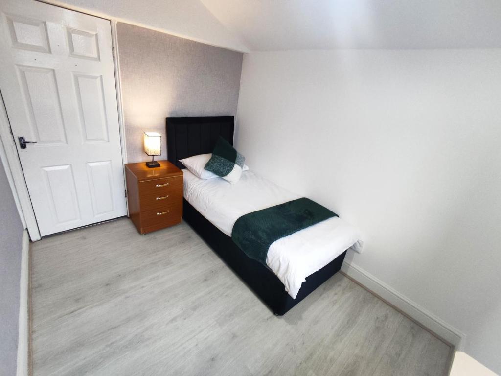 3 Bedroom Entire House في ميدلسبرو: غرفة نوم صغيرة بها سرير وباب