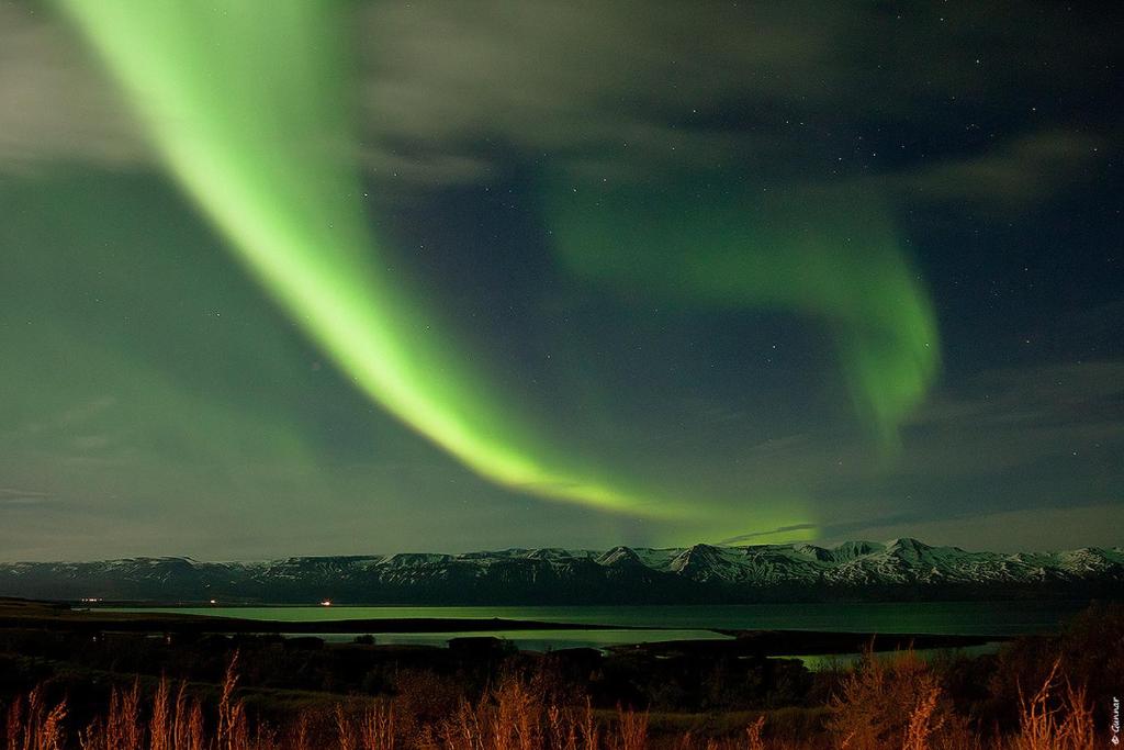 an image of the northern lights in the sky at Kaldbaks-kot cottages in Húsavík