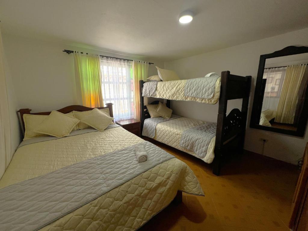 a bedroom with two beds and a bunk bed at Anhyali Hospedaje in Villa de Leyva