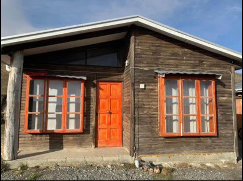 Casa de madera pequeña con puertas y ventanas de color naranja en Cabañas Hain, en Porvenir