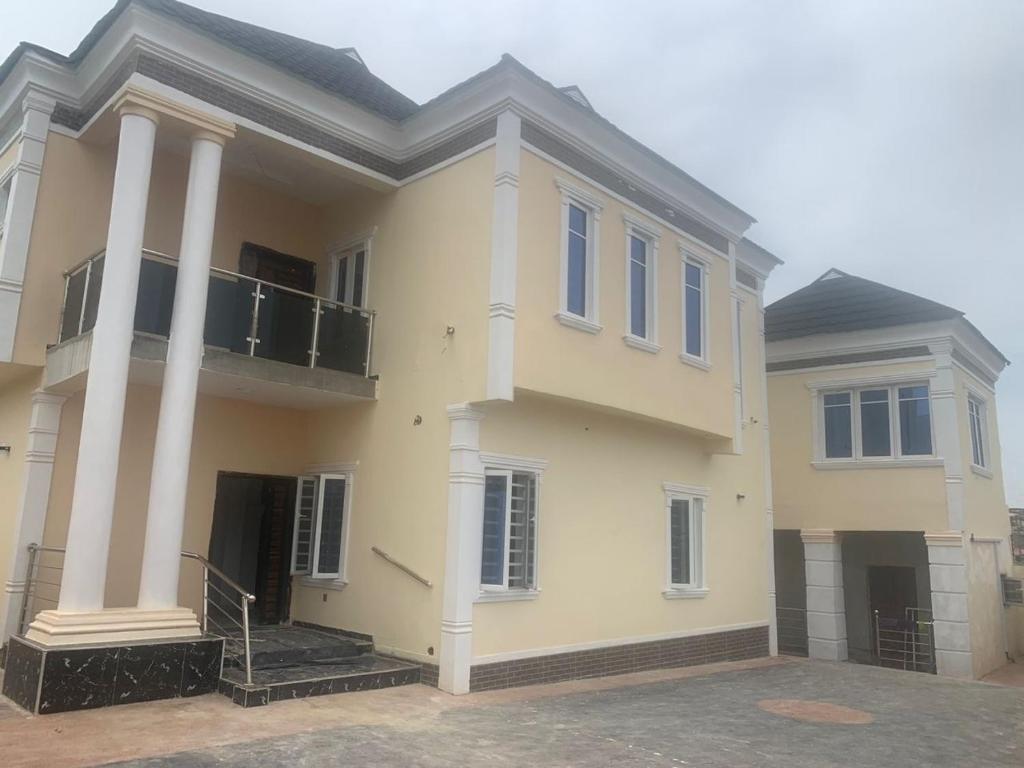 une grande maison blanche avec des colonnes et un balcon dans l'établissement 2 bedroom flat Apartment, à Ibadan
