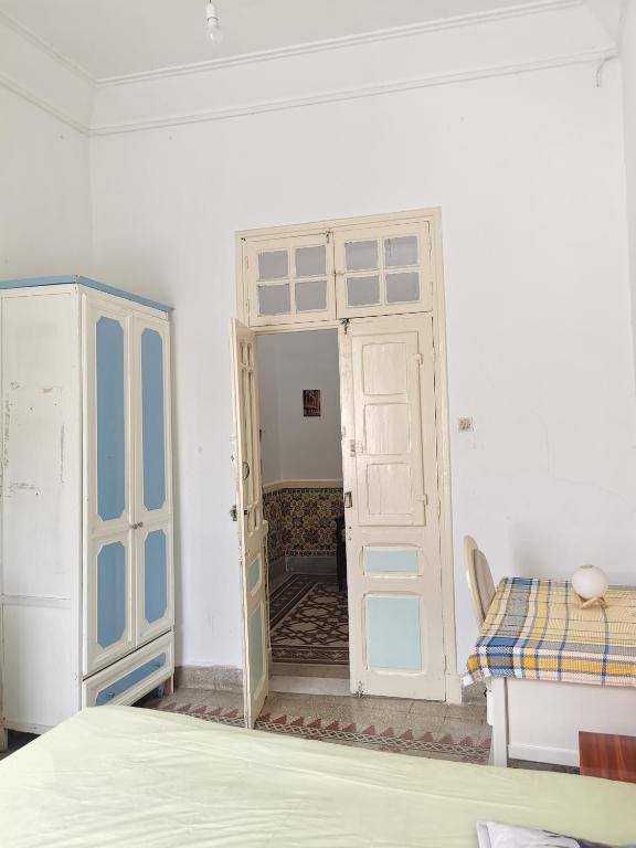uma porta aberta num quarto com uma cama e uma mesa em Dar Mima Baya em Tunes