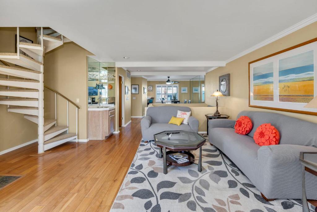 a living room with two couches and a staircase at Pine Street #2 in Oceanside
