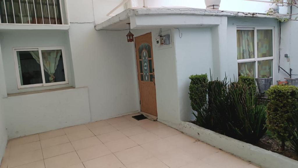 a white house with a door and a patio at Casa Boulevard in Mexico City