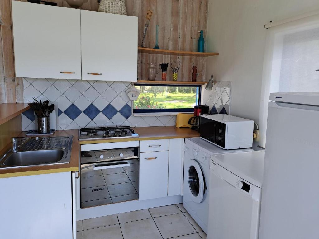 a small kitchen with white cabinets and a sink at Holiday home in a secluded location surrounded by the sea, Hanvec in Hanvec