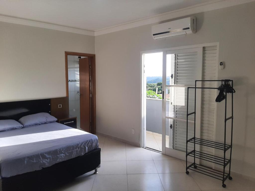 una camera da letto con un letto e una porta su un balcone di trabalho ou lazer a Marília