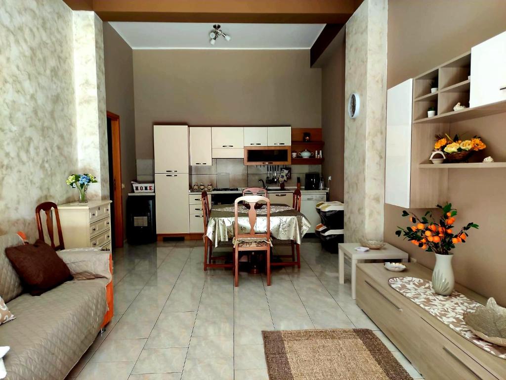 sala de estar con mesa y cocina en Etna Holiday Apartment - Casa Vacanze en Fiumefreddo di Sicilia