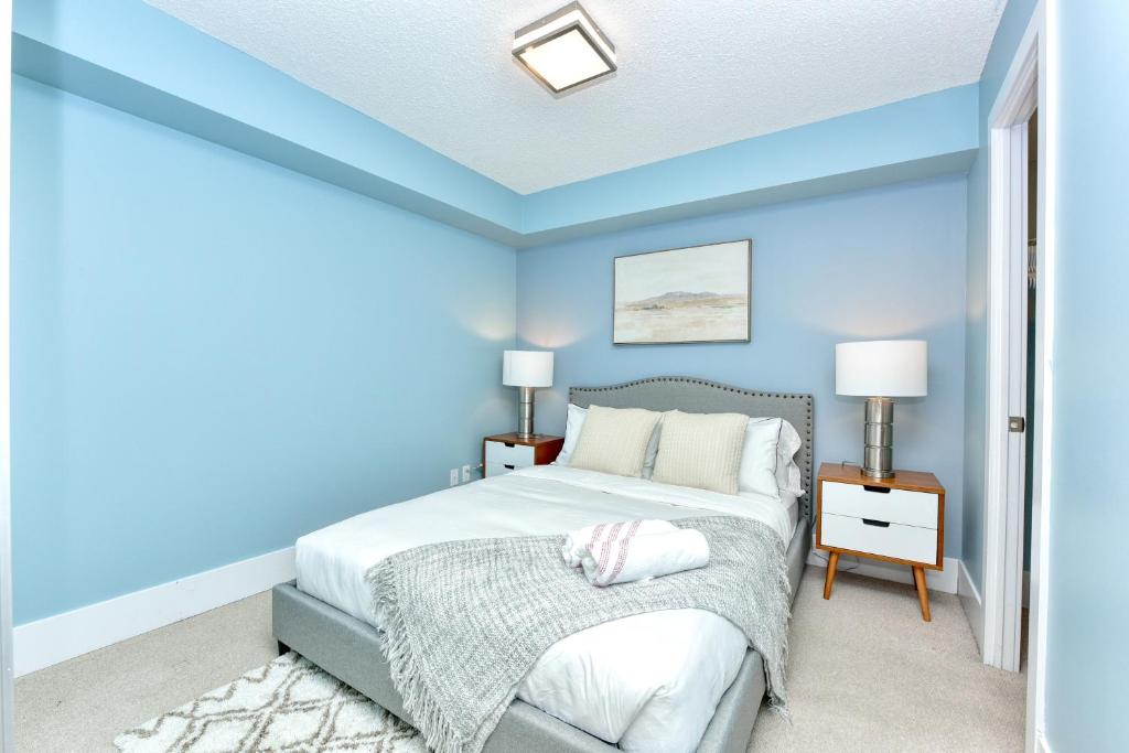 a bedroom with blue walls and a bed with white pillows at 300 Front Suites in Toronto