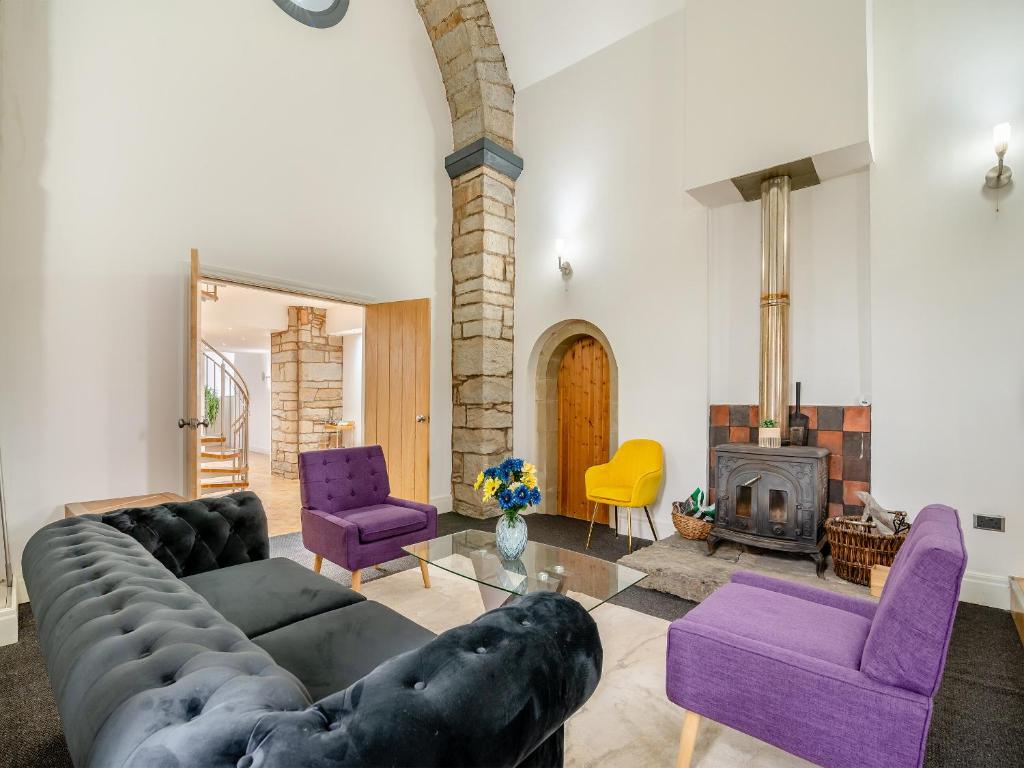 羅森代爾的住宿－The Old Church，客厅配有大沙发和紫色椅子